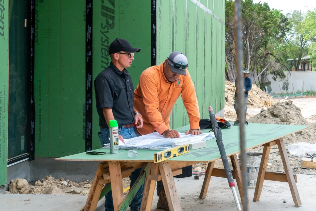 Two people looking over construction plans