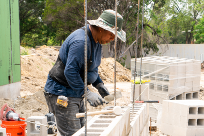 Construction worker building a cinder block wall