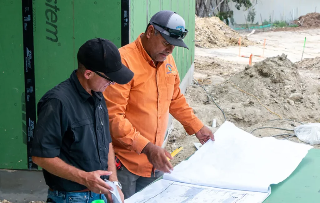 Two construction workers looking at blueprints
