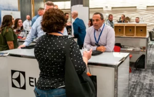 A woman and man chatting at a vendor expo