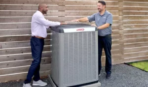 two men outside standing next to HVAC