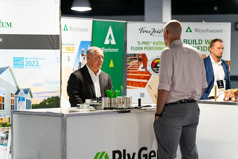 two men speaking at booth