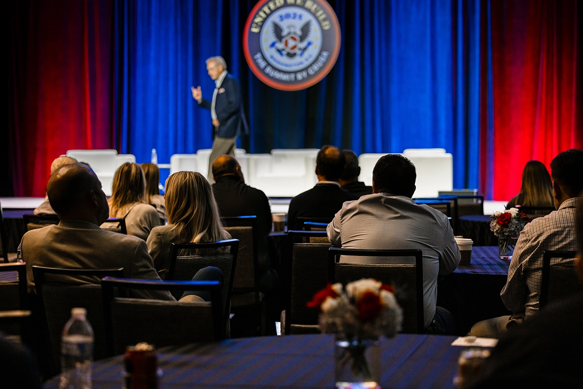 CBUSA Summit attendees listening to a speaker during a conference presentation.