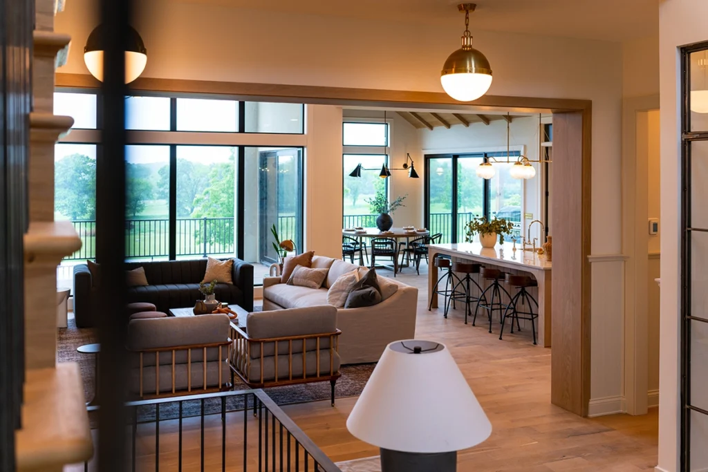Open-concept custom home interior with a living room, kitchen and dining area overlooking the backyard.